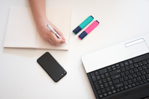 A person writing at the desk